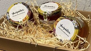 Da sitzen die drei Spezialitäten in ihrer Geschenkpackung und warten auf Kunden: würziger Kastanienhonig, ausgewogener Auwaldhonig und milder Wiesenblütenhonig.