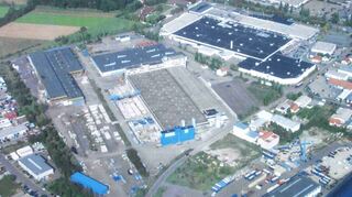 Ein Luftbild des Talhauses, in dessen Mittelpunkt die Betriebsstätte der Firma Süba zu sehen ist. Die dunkelblaue Fläche am rechten oberen Bildrand zeigt das Dach des Massa-Supermarktes – heute der Sitz des Globus-Marktes. Gut zu erkennen am Massa-Markt ist die helle Fläche des Parkdecks. Um die Ansiedlung des Marktes gab es Mitte der 1970er Jahre einen heftigen Rechtsstreit mit der Stadt Wiesloch. Zwar ging dieser zugunsten von Hockenheim aus, doch in der Folge verzichtete Bürgermeister Dr. Kurt Buchter auf die Ansiedlung von Ikea im Talhaus.