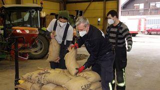 Die Feuerwehr Altlußheim packt Sandsäcke.