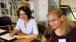 Sanja Aleksic und Yevgine Dilanyan zeigen bei einem Tag der offenen Tür, wie Komponisten mit der Feder die Noten geschrieben haben.