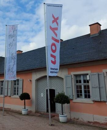 Mit Fahnen macht sich das Xylon-Museum mehr bemerkbar.