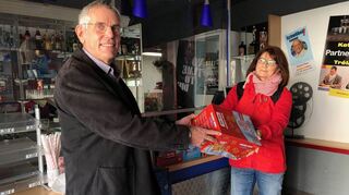 Pfarrer Christian Noeske nimmt die Kinosnacks von Monika Gräble aus dem Orgateam des Central Kinos in Empfang.