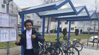 Moses Ruppert zeigt auf den Fahrplan an der Haltestelle. Im Bereich ÖPNV hat der 21-Jährige schon einiges bewegt.