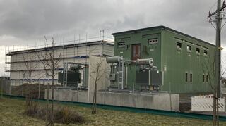 Der helle Neubau und der grüne Altbau auf dem Gelände des Brühler Umspannwerks. Im Vordergrund erkennt man die beiden E-Kompensationseinheiten, die demnächst für die richtige Spannung sorgen.