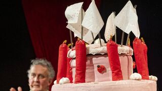 Unübersehbar: Theaterleiter Matthias Folz moderiert hinter einer Geburtstagstorte aus dem Theaterfundus die Geburtstagsfeier.