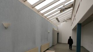 Blick in den Eingangs- und Aufenthaltsraum der Flüchtlingsunterkunft. Rechts befinden sich hinter der notdürftig eingebauten Wand die Squashplätze.