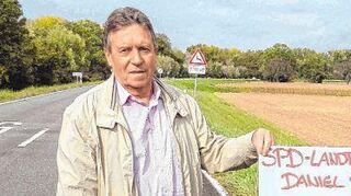 Landtagsabgeordneter Daniel Born (r.) und SPD-Gemeinderat Dieter Hoffstätter mit einem Schild vor Ort am Rheindamm in Richtung Ketsch.