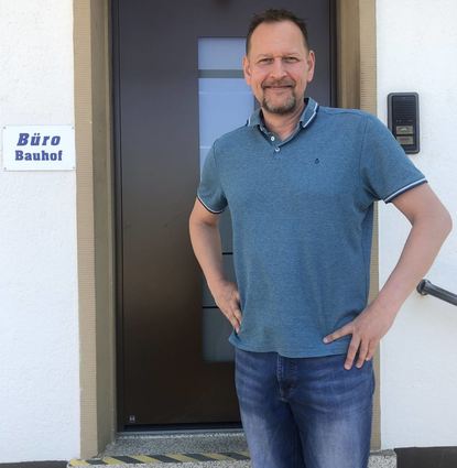 Marcus Schütterle ist der neue Leiter des Bauhofs. Mit einem Lächeln steht er vor dem Büro des Bauhofes.