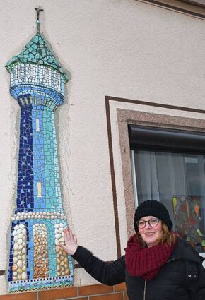 Die Künstlerin zeigt stolz den Wasserturm an der Hauswand in der Seegasse 6.