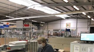 Schutz für die Mitarbeiter: In der Knapp-Produktion verpackt eine Mitarbeiterin mit Maske die Ware.