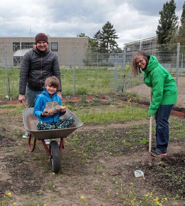 Die ersten Aktiven rund um den Begegnungsgarten – Sandro und Jonas Schiefner (im Schubkarren) sowie Astrid Tippelt – haben bereits Hand angelegt.