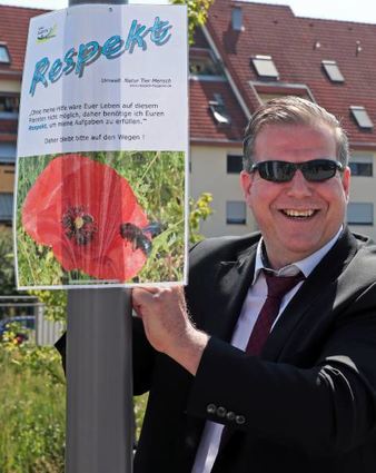 OB Marcus Zeitler hilft beim Aufhängen der Plakate am Bachlauf tatkräftig mit.