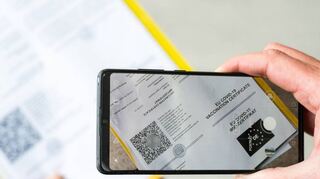 Ein Mann scannt mit einem Handy ein Dokument für den Digitalen Impfnachweis. Der CovPass ist ein zusätzliches Angebot, der gelbe Ausweis gilt weiter.