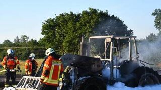 Die Feuerwehr muss den in Vollbrand geratenen Traktor löschen.