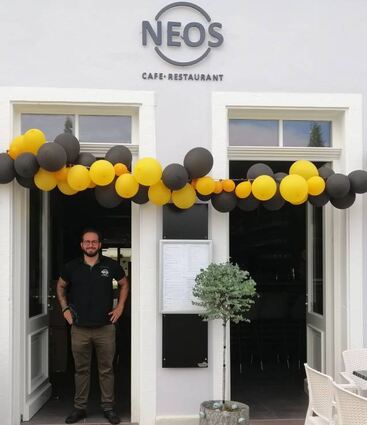 Panagiotis Karavasilis steht im Eingang seines Restaurants. Die Luftballons zeugen noch von der spontanen Eröffnung.