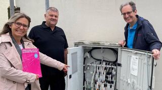Bürgermeister Göck (r.) lässt sich die „Pipes“ in einem der 63 Glasfaserverteilerkästen, die in ganz Brühl verteilt sind, von Telekom-Regionalmanagerin Anna Pia Engel und ihrem Mitarbeiter Michael Zafirov zeigen.