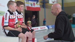 Szene aus dem Dokumentarfilm „Die letzten Reporter“: Tom Willmann (r.), Sportreporter für die Schweriner Volkszeitung, interviewt zwei junge Nachwuchssportler nach der Pokalübergabe.