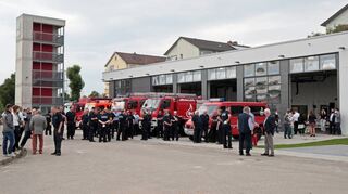 Einige geladene Gäste sind zur Übergabe des neuen Rettungszentrums gekommen. Auch die Einsatzfahrzeuge stehen schon bereit.