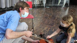 Musiklehrer Stefan Knust zeigt Mathilda Bangert (6) im Danzi-Saal der Musikschule, wie man einem Violoncello Töne entlocken kann.