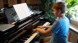 Daniel Stang spielt Klavier auf seinem Flügel im Wohnzimmer in Eppelheim. Hier hat er die Videos für die Online-Wettbewerbe aufgenommen, die dann um die ganze Welt geschickt wurden.