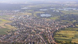 Die Gemeinde aus der Vogelperspektive. Unten ist der Sportplatz, dahinter die Firma Metalux zu erkennen. Der Halbbogen von Haupt- und Rheinhäuser Straße umschlingt am rechten Bildrand das Niederfeld. Parallel zur Ortsrandbebauung verläuft der Nieder-feldweg, der weiterhin die Grenze der Bebauung bilden soll. Mit dem neuen Bebauungsplan soll in erster Linie das Bauen in der zweiten Reihe zwischen Niederfeldweg und Rheinhäuser Straße geregelt werden.