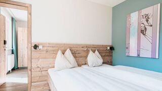 Lässige Farben und viel Raum im Cooee alpin Bad Kleinkirchheim: Die Etagen sind mit Plätzen zum Verweilen ausstaffiert. Fotos von Rainer Schönfelder (r.) hängen an den Wänden. Mittig ist der Zugang zu einem behindertengerechten Zimmer zu sehen.
