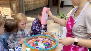 Mit der Farbschleuder entstehen bei der Begegnungsstätte im Wald tolle Kunstwerke der Ferienkinder.