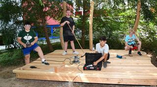 Siebtklässler der Friedrich-Ebert-Gemeinschaftsschule machen sich an die Arbeit und schaffen die Arena – eine Bühne und eine Treppe sowie einen Zugangsweg. Mit dabei sind David, Gian-Luca, Luan und Morice (v. l.) und Lehrer Markus von Dahl.