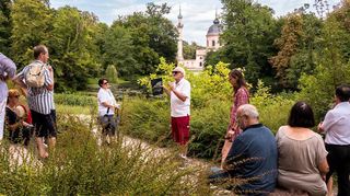 Eine Gruppe erfährt bei der Sonderführung „Die Entführung in den Serail – Moschee und Gartenmode“ viele spannende Details von Dr. Christoph Bühler.