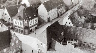 Blick auf die Fortuna-Kreuzung vom katholischen Kirchturm im Jahre 1934: Das Gasthaus „Fortuna“ nimmt den gesamten Vordergrund ein mit seiner stattlichen Anlage um einen Innenhof. Nach seinem Abriss bot die Stelle ein „trostloses Bild“, sagte Bürgermeister Schrank 1981. Links die Metzgerei Eichhorn und das Kaufhaus Gärtner.
