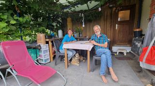 Familie Lambert samt Vierbeiner „Tano“ in ihrer Freiluft-Behelfsküche auf der kleinen Dachterrasse des Hauses. Diese wurde mit einer Plane überspannt gegen den Regen.