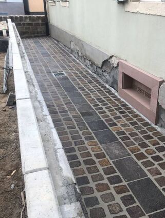 Am Pfarrhaus ist der Graben bereits neu gepflastert.