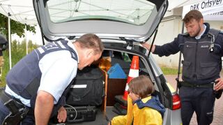 Die fünfjährige Louisa stellt Michael Keller (links) und Alexander Ortlieb von der Polizei neugierig Fragen zu ihrem Dienstfahrzeug und dessen Ausrüstung.