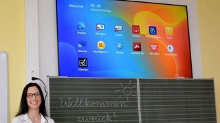 Schulleiterin Sandra Worrow mit einem der Tablets für den Unterricht, mit dem sich auch der Monitor oberhalb der traditionellen Schultafel bedienen lässt.