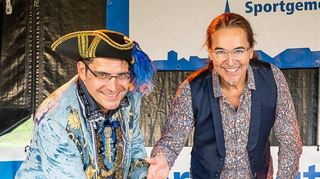 Fürstliches Geschenk: „Edelmann“ Stefan Weisbrod überreicht Moderator Chako Habekost am Tag der Dorfgemeinschaft einen Reilinger Käsekuchen.