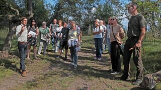 Bei der geführten Exkursion mit Forstbezirksleiter Philipp Schweigler (l.) erfahren die Besucher viel über die wichtigen Funktionen des Waldes, aber auch über die Gefahren, die den Bäumen durch den Klimawandel drohen.
