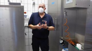Der hauptamtliche Gerätewart Lars Hoffmann präsentiert eine neue Industriewasch-maschine sowie den Prototypen der ersten Imprägnierkabine für die Einsatzkleidung der Feuerwehr.