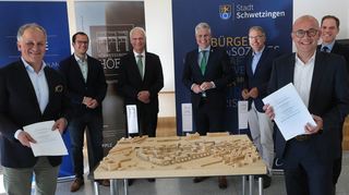 Ein richtungsweisender Termin: Epple-Geschäftsführer Andreas Epple mit Matthias Ohlheißer und Dr. Thomas Grimann von Ceonceptaplan, Bürgermeister Matthias Steffen, Wolfgang Leberecht vom Amt für Wirtschaftsförderung, Oberbürgermeister Dr. Rene Pöltl und Patrick Körner von der Wohnbaugesellschaft unterzeichnen den städtebaulichen Vertrag. Auf dem Tisch steht ein Modell, wie das künftige Quartier „Schwetzinger Höfe“ aussehen soll.