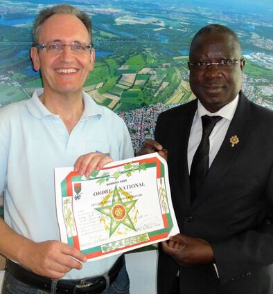 Dourtengas Bürgermeister Armand Abgas überreicht 2018 an seinen Amtskollegen Dr. Ralf Göck eine Urkunde, die den Rathauschef zum Großmeister des Nationalordens von Burkina Faso ernennt.