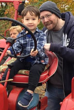Eric (hier mit seinem Papa) ist ganz begeistert von Traktoren.