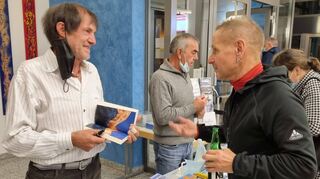 Hier treffen zwei Bergsportler aufeinander: Peter Pludra (r.) aus Brühl hat eine Kletterschule („Gecko-Klettern“) und bewundert Hans Kammerlander. Die beiden plaudern übers Skifahren und das Klettern. Kammerlander hat viele Bücher über seine Erlebnisse veröffentlicht. Hinten: Anton „Toni“ Mutschlechner, ein Wanderführer aus Südtirol und Freund von Hans Kammerlander. Fürs Foto haben alle ganz kurz die Masken auf Bitte hin abgenommen.