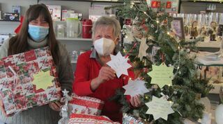 Inge Oetzel (r.) positioniert die Weihnachtswunschsterne am Christbäumchen in der Mannheimer Straße 81. Ihre Tochter Renate Wohlfahrt bringt die größten Päckchen ins Lager, denn der Platz wird eng im Geschäftsraum.