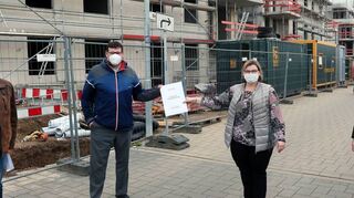 Bernhard Müller von der Stabsstelle Umwelt der Gemeinde Plankstadt, Bürgermeister Nils Drescher, Martina Braun als Geschäftsführerin der Stadtwerke Schwetzingen und der Technische Prokurist der Stadtwerke Ronny Weber präsentieren den gemeinsamen Fernwärme-Gestattungsvertrag – passenderweise vor dem Antonius-Quartier, dem ersten Projekt, das an die Fernwärme angeschlossen wurde.