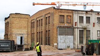 Die Rückwand dieser Halle bleibt erhalten und wird in einen Neubau integriert. In das kleine Gebäude links ziehen Künstler ein.