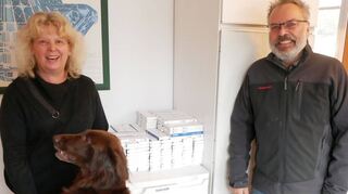 Gartenbaumeister Rolf Simianer, seine Frau Sabine Schmitt und ihr Hund „James“ vor ihrem großen Vorrat an Selbsttests für die Mitarbeiter – der aber spätestens an Weihnachten aufgebraucht sein wird, wenn kein Nachschub kommt.