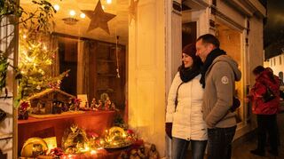 Ein Pärchen auf dem Diezer Krippenweg vor einem Schaufenster: In der Adventszeit bis zum Dreikönigstag ist in Diez das Krippchengucken eine beliebte Tradition.
