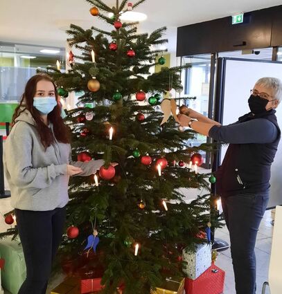 Christina Heller vom IB (r.) und FSJlerin Vanessa Schneider geben dem Weihnachts-baum in der Eingangshalle der GRN-Klinik den letzten Schliff.