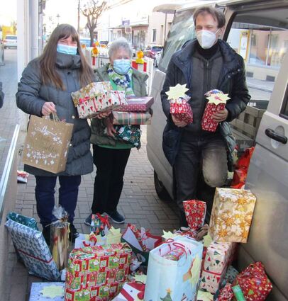 Renate Wohlfahrt (v. l.) und Inge Oetzel vom gleichnamigen Geschäft packen mit Frank Loreth die Geschenke für die Kinder ins Auto.