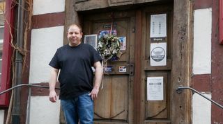 Mario Böhm vor der historischen Eingangstür seines Wirtshauses „Güldener Engel“ in der Heidelberger Straße. Die verschiedenen Aushänge erklären die aktuell geltenden Regeln für einen Restaurantbesuch.