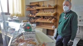 Bei „Appel + Ei“ gibt es jetzt auch einen Bäckerei-Tresen. Richard Bohrmann richtet Brot, Brötchen und süße Teilchen ansprechend her.